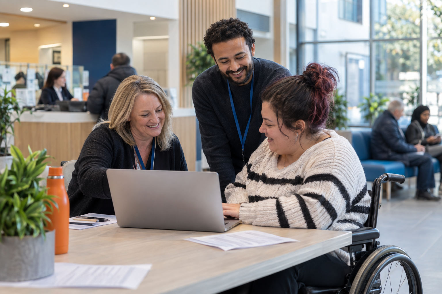 Public sector staff helping a wheelchair user access an online service at a civic centre