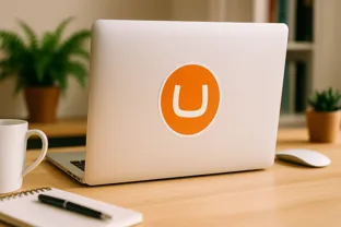 An open laptop facing away from you with an Umbraco sticker on the front cover
