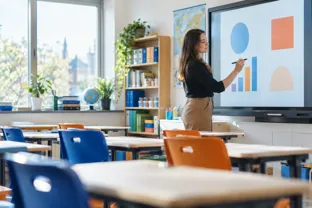 Teacher using an interactive display in a modern UK classroom